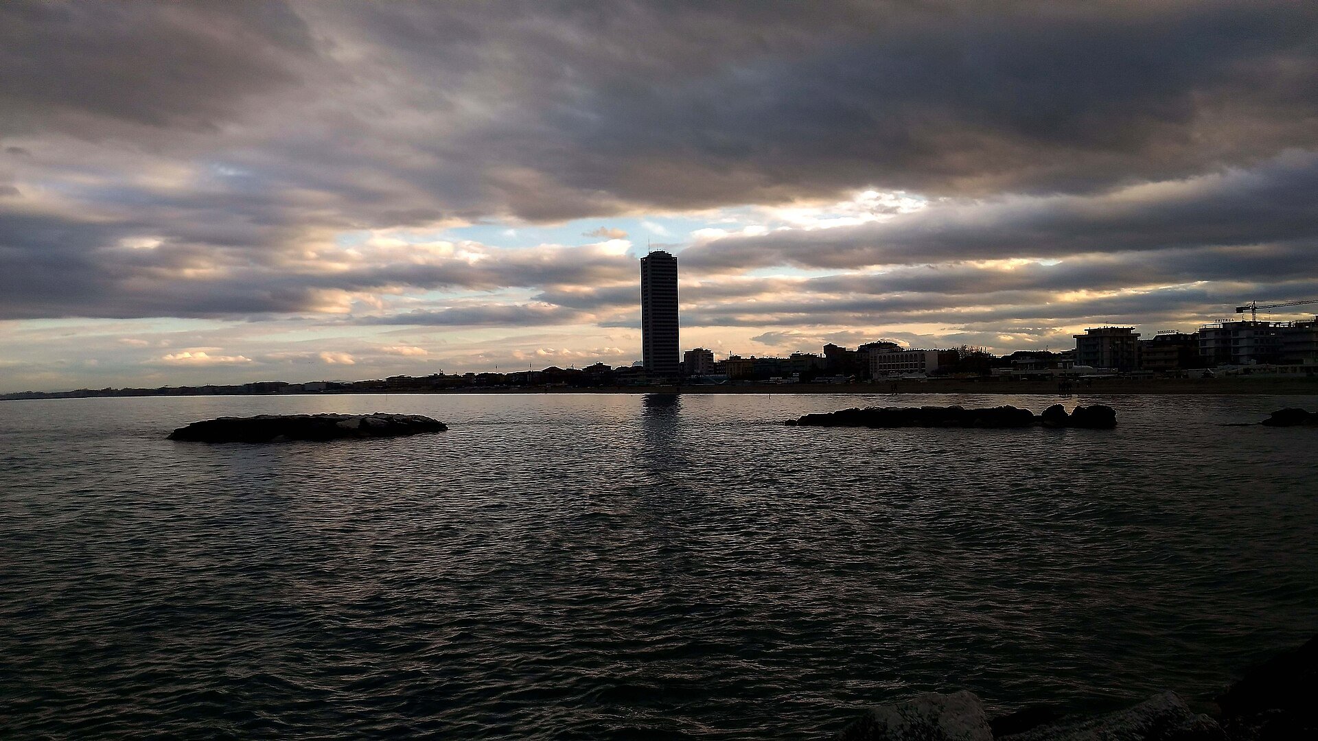 Cesenatico seen from the sea towards evening, with the skyscraper in the background