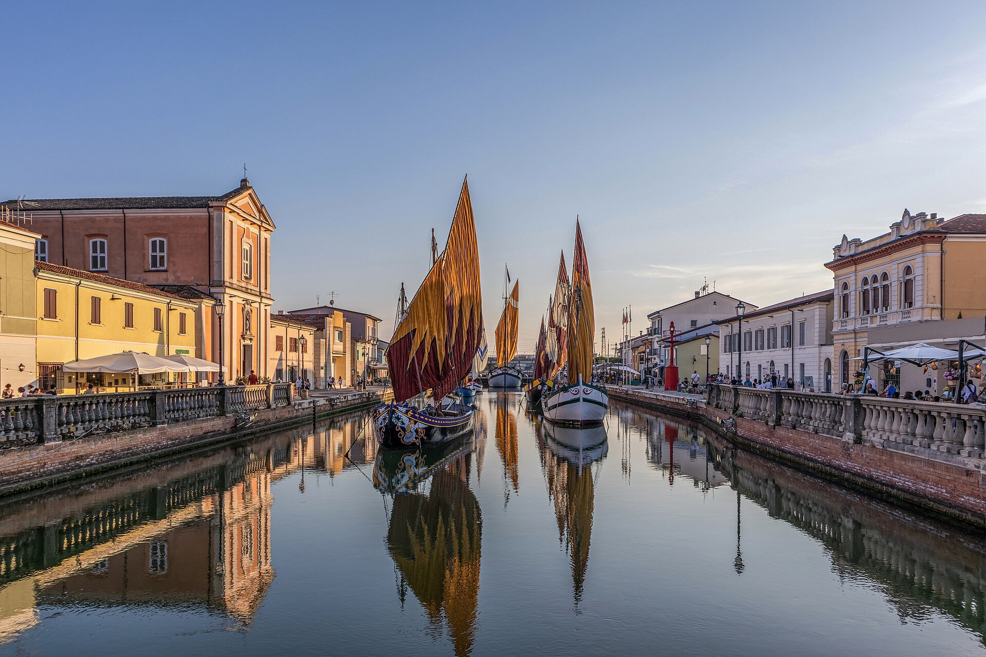 Historic boats with painted lugsails moored in the canal harbour of Cesenatico